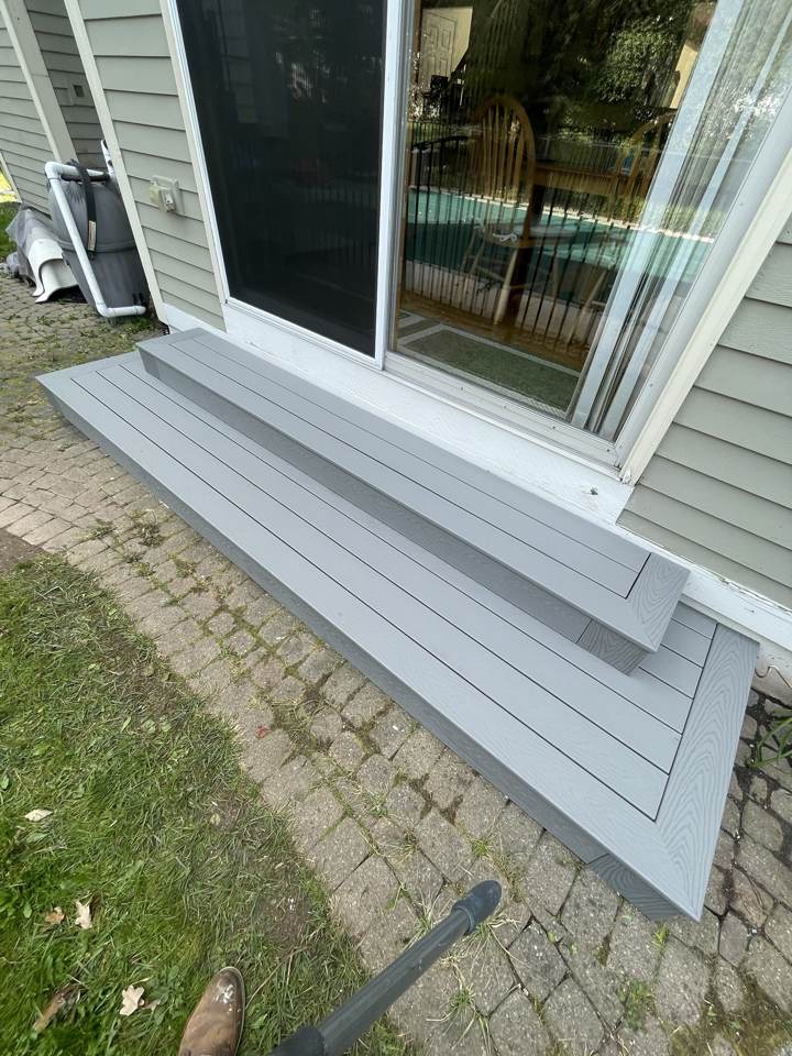 New gray composite deck steps at a sliding door