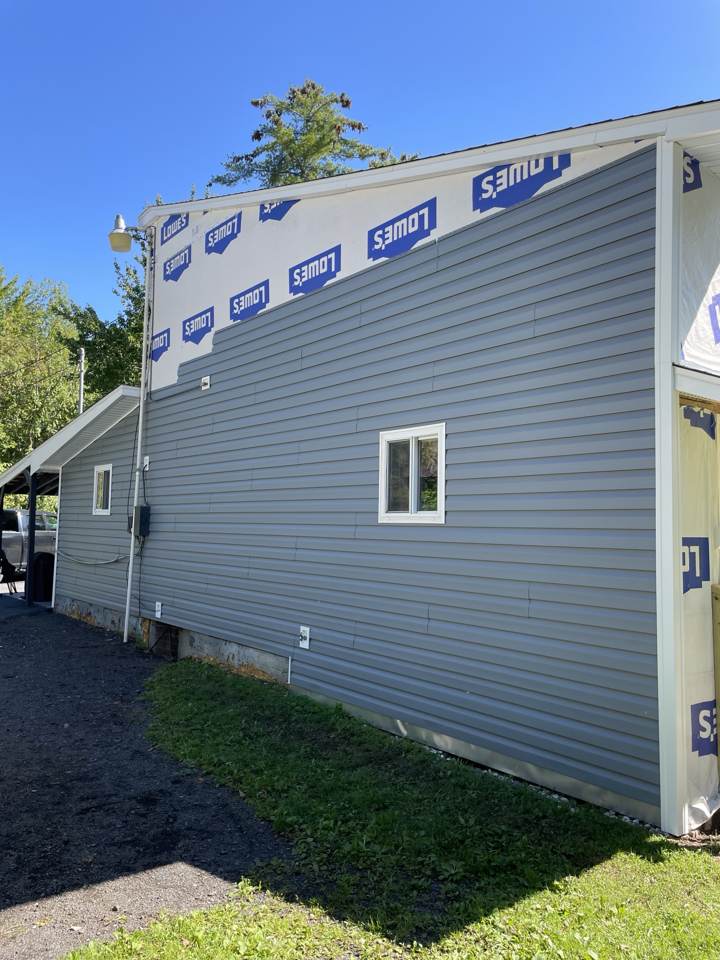 New gray vinyl siding over house wrap on a home