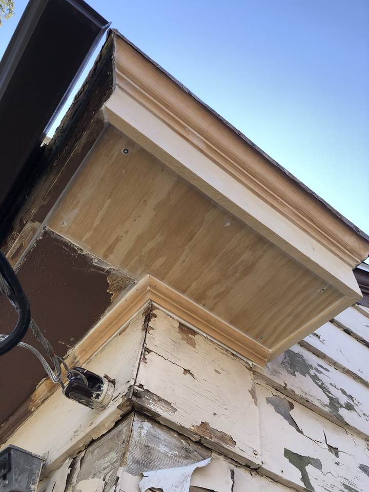 Rotted and peeling fascia and soffit at a roof corner