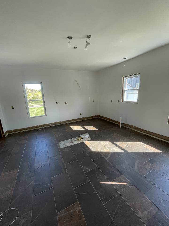 Large-format dark tile floor installed in a room