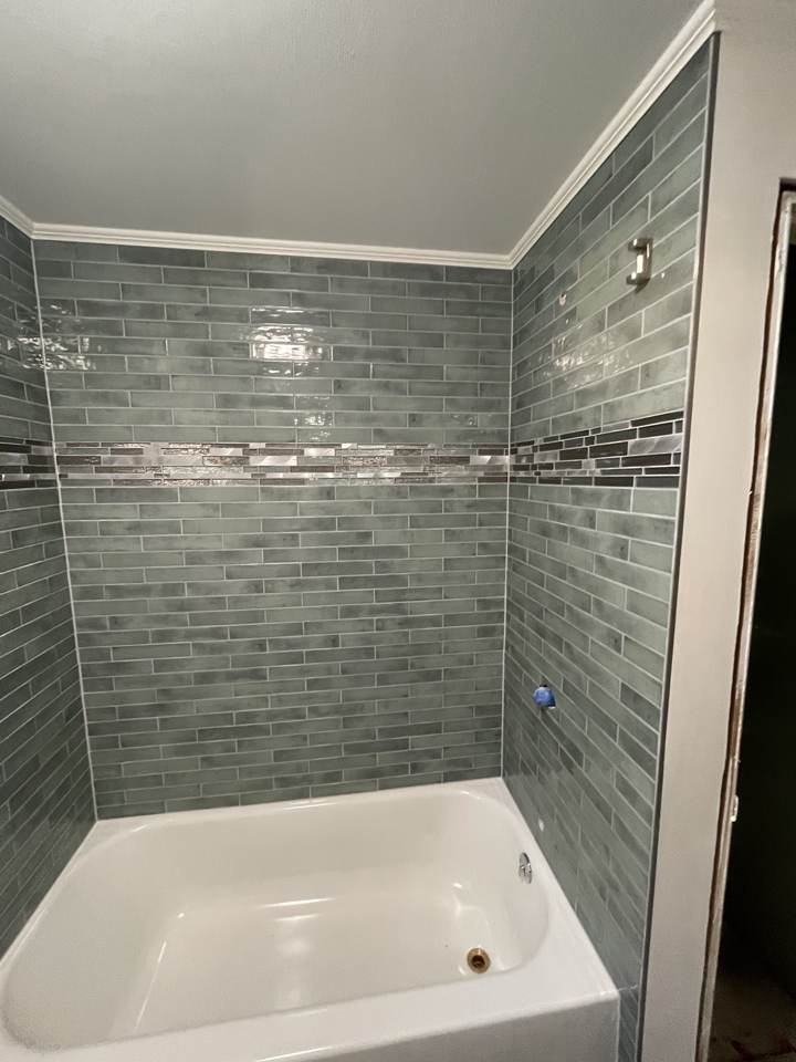 Tiled tub surround with metal accent band